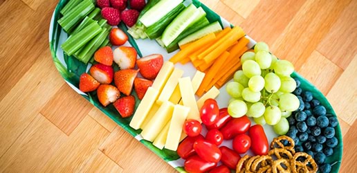 Fruit platter with cut up veggies and pretzels